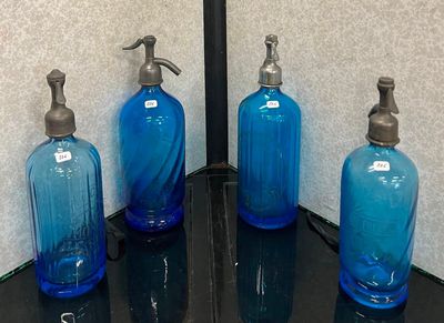 trois bouteilles en verre bleues posées sur un comptoir noir
