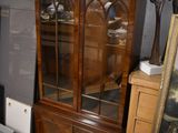 a cabinet with a glass door and a mirror on it