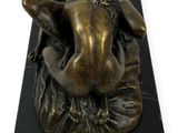 statue of a nude woman on a black marble base on a white background