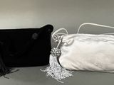 black and white purses with tassels sitting on a table