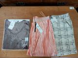 two skirts and a shirt are sitting on a table next to each other