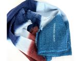 une écharpe bleue et rouge et une écharpe bleue et blanche posées sur une surface blanche