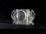 a glass clock sitting on top of a black table