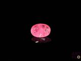 La boule rose brille dans le noir et sa surface reflète la lumière.