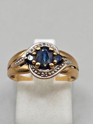 a close up of a gold ring with a blue sapphire stone