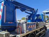 a blue crane that is sitting on the back of a truck