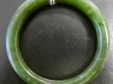 an image of a green jade bangle with a string around it