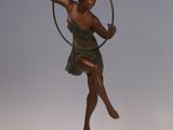 statue d'une femme portant un cerceau, posée sur un socle en marbre