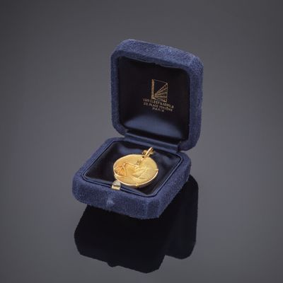 une image représentant une médaille d'or dans un écrin en velours bleu