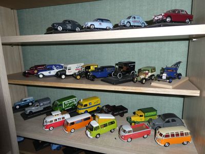 many toy cars and trucks on a shelf in a room