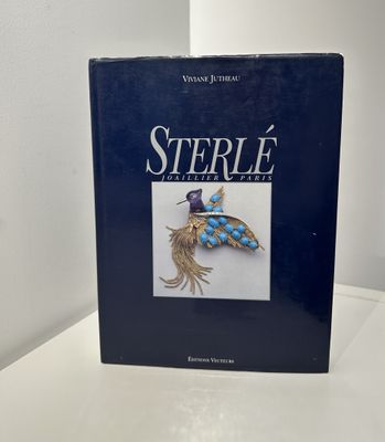 le livre est posé sur une table près d'un mur blanc