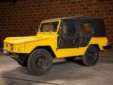 a yellow jeep parked in a garage with a brick wall