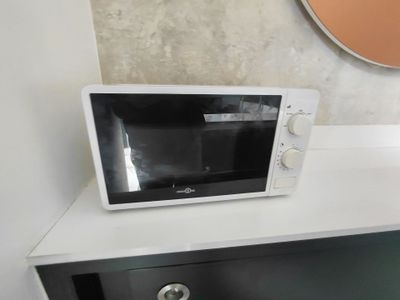 un micro-ondes posé sur une commode dans une pièce