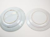 two white plates on a white table with a white background