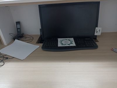 un ordinateur portable posé sur un bureau, à côté d'un clavier