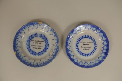 une paire d'assiettes bleues et blanches ornées d'une citation