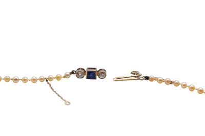 a close up of a bracelet with pearls on a white background