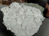 a piece of rock with white crystals on top of it