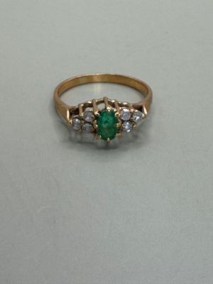 a close up of a gold ring with a green stone