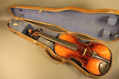 un violon dans son étui, posé sur une table