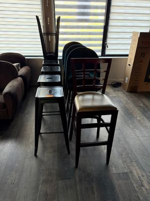 several chairs and a table in a living room with a couch