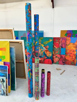 a room filled with art supplies and paintings on the walls