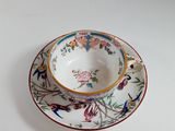 a tea cup and saucer on a white table