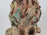 a ceramic sculpture of a frog sitting on a rock