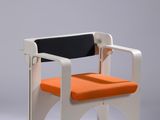 an orange and white chair with a black seat on a grey background