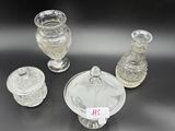 three clear glass vases and a small glass bowl on a black surface