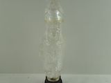 a clear glass vase with a black base on a white surface