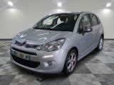 the small silver car is parked on a checkered tile floor