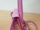 purple leather purse with a gold handle on a wooden table