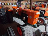 a tractor that is sitting in a garage with other tractors
