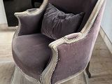 une chaise violette sur laquelle est posé un coussin, dans une pièce