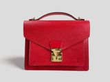a red handbag with a gold lock on the handle
