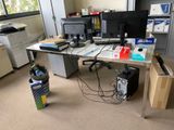 a desk with two monitors and a printer on it