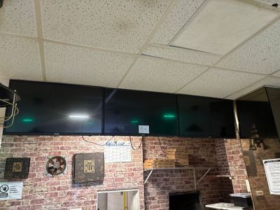 un mur en briques dans un restaurant, avec une horloge accrochée au mur