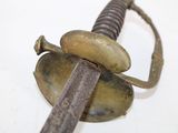 a close up of a sword on a white surface