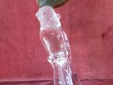 a glass figurine of a bird with a green leaf on its head