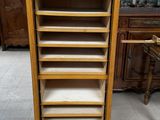 a tall wooden cabinet with drawers and drawers on top of it