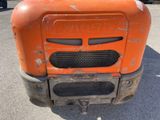 a rusted orange tractor parked in a parking lot