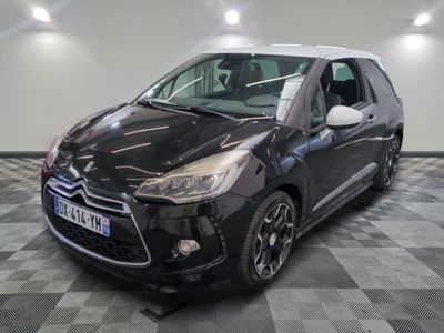 la petite voiture noire est garée sur un sol en damier