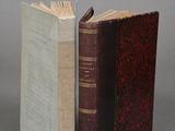 two books sitting side by side on a table with a gray background