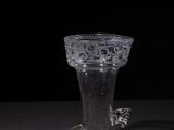 a clear glass vase with a silver handle on a table