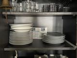 de nombreuses assiettes et verres sur les étagères de la cuisine