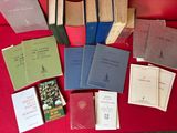 many books sitting on a red table with a red chair