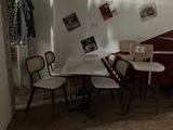 a table and chairs in a room with pictures on the wall