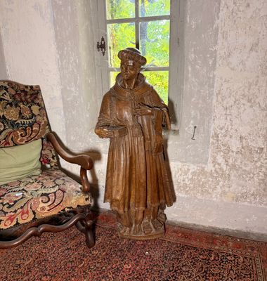 une statue représentant un homme debout à côté d'une chaise dans une pièce