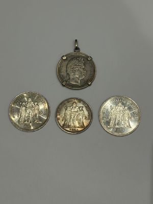 trois pièces d'argent posées l'une à côté de l'autre sur une surface blanche